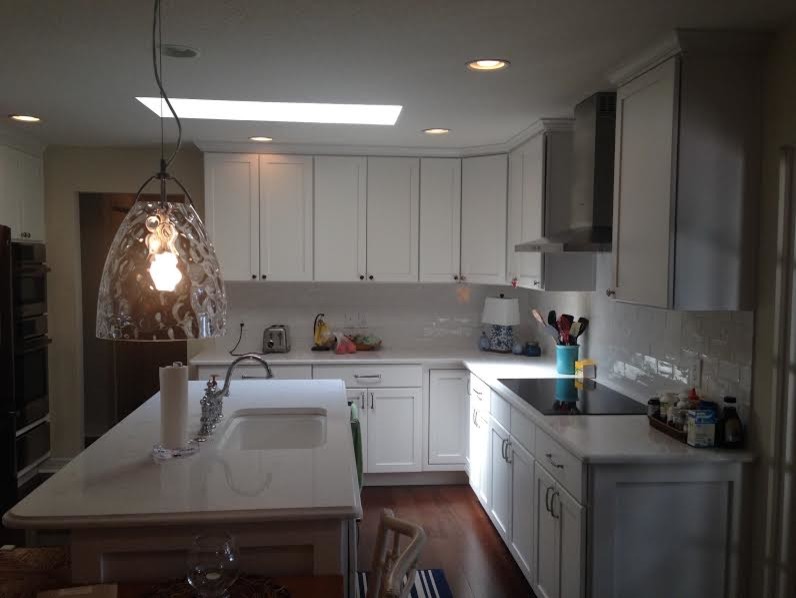 Eat-in kitchen - large transitional l-shaped dark wood floor eat-in kitchen idea in Orlando with a drop-in sink, shaker cabinets, white cabinets, laminate countertops, white backsplash, ceramic backsplash, stainless steel appliances and an island