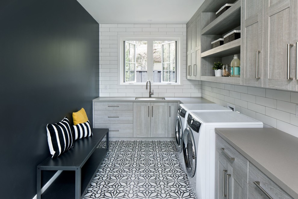 Design ideas for a country l-shaped laundry room in San Francisco with an undermount sink, flat-panel cabinets, grey cabinets, black walls and a side-by-side washer and dryer.
