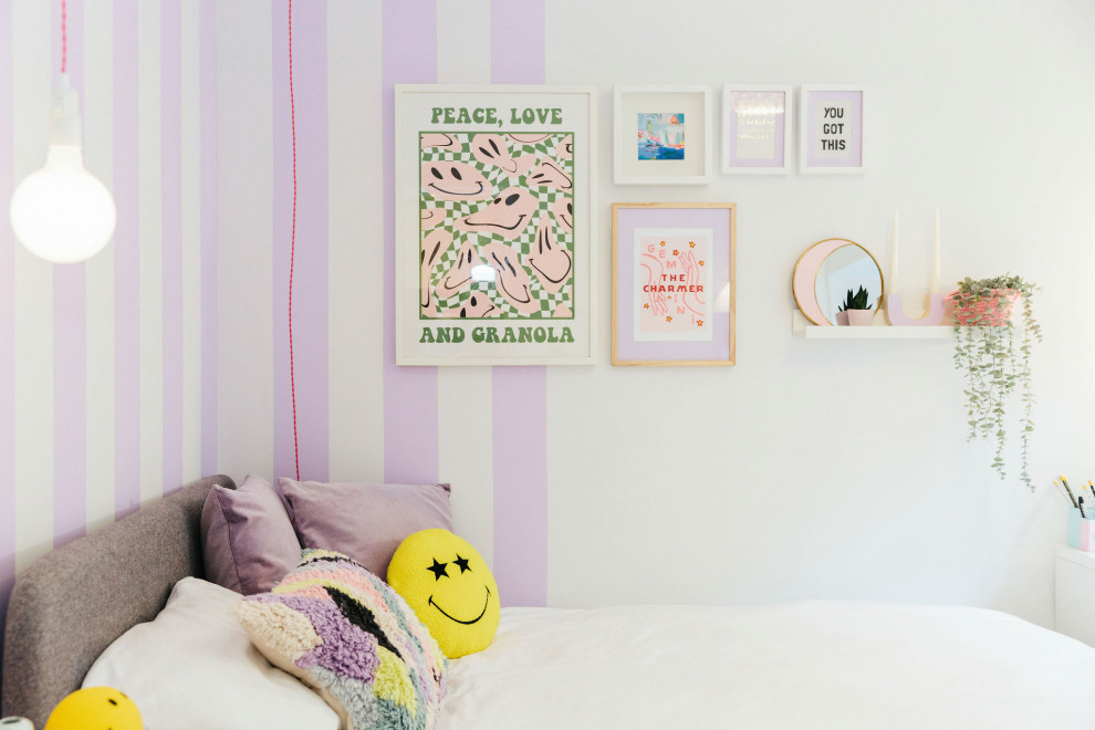 This is an example of a medium sized modern teen’s room for girls in Dorset with purple walls, light hardwood flooring and brown floors.