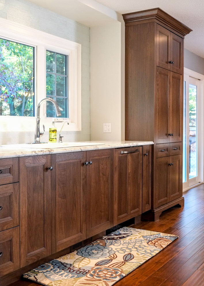 Eat-in kitchen - mid-sized transitional medium tone wood floor eat-in kitchen idea in Calgary with a drop-in sink, recessed-panel cabinets, medium tone wood cabinets, laminate countertops, blue backsplash, glass tile backsplash, stainless steel appliances and an island