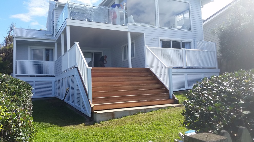 Design ideas for a mid-sized country front yard screened-in verandah in Wollongong with decking.