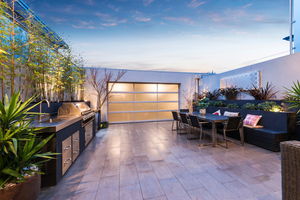 Photo of a mid-sized contemporary courtyard patio in Melbourne with an outdoor kitchen, tile and no cover.