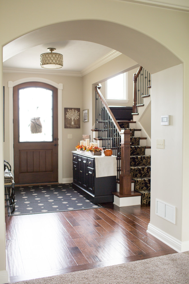 Example of a mid-sized transitional medium tone wood floor and brown floor front door design with beige walls and a medium wood front door