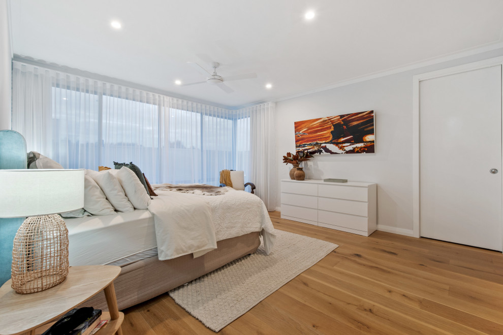 Inspiration for a large contemporary master bedroom in Perth with medium hardwood floors, beige floor and grey walls.