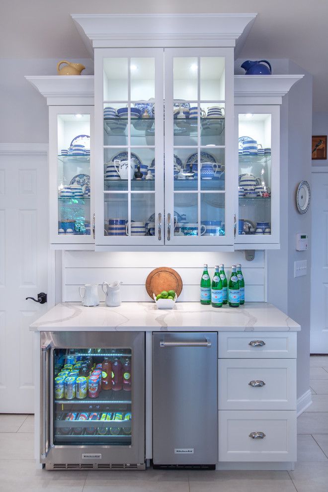 Inspiration for a small country single-wall wet bar in Charlotte with glass-front cabinets, white cabinets, white splashback, subway tile splashback, white floor and white benchtop.