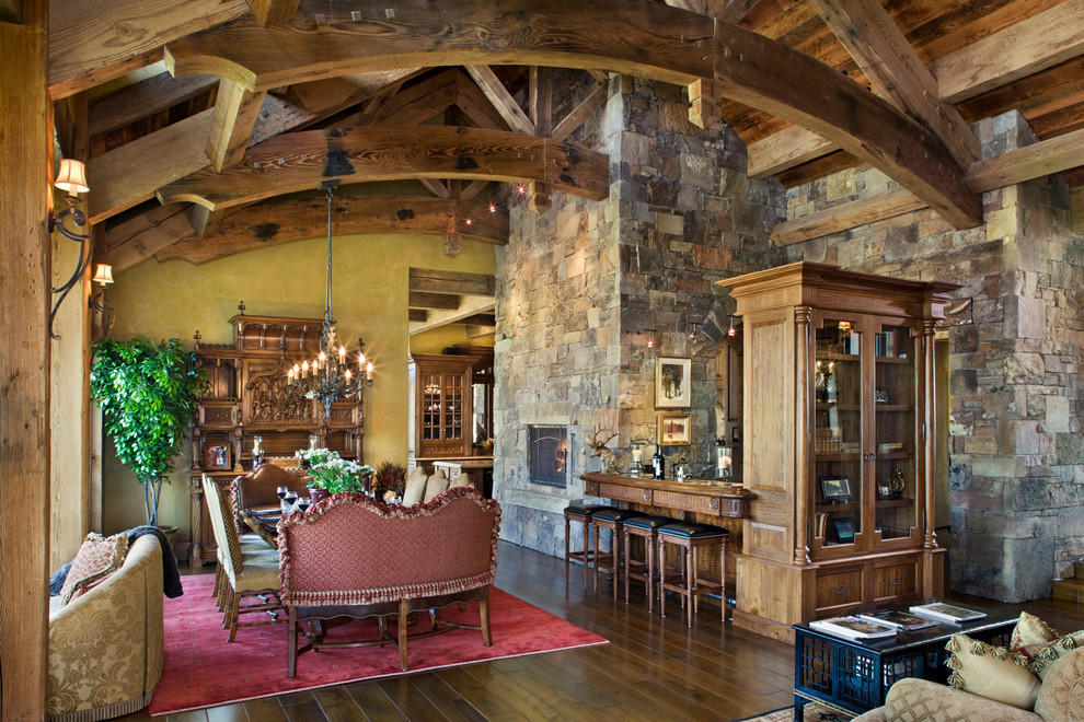 This is an example of a country dining room in Other with yellow walls and dark hardwood floors.