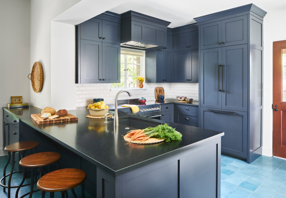 Inredning av ett klassiskt mellanstort svart svart u-kök, med skåp i shakerstil, blå skåp, vitt stänkskydd, en halv köksö, blått golv, en undermonterad diskho, stänkskydd i tunnelbanekakel och integrerade vitvaror
