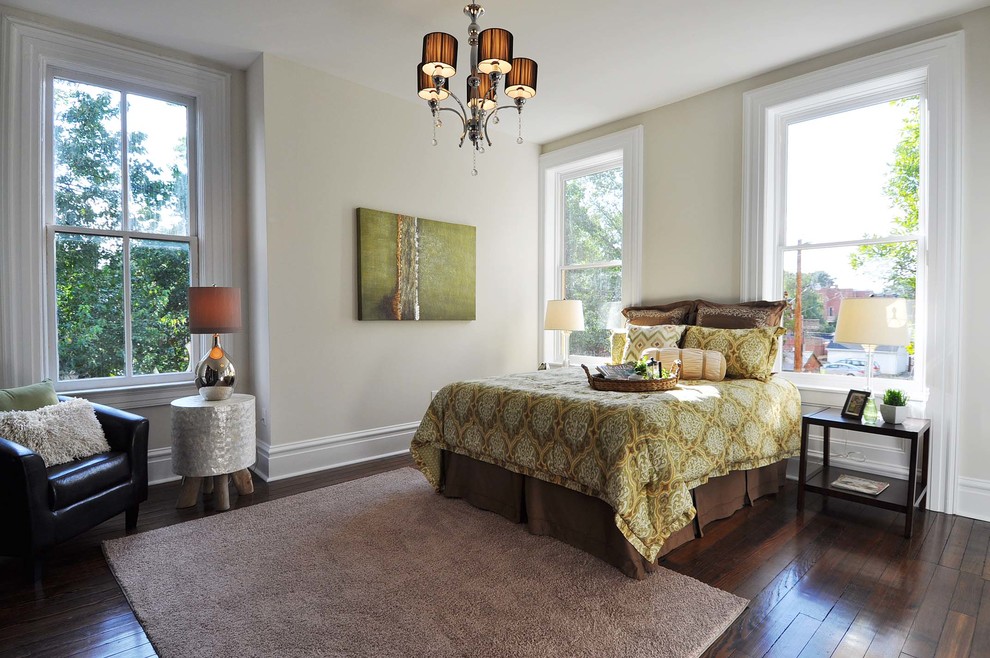 Mid-sized traditional master bedroom in St Louis with dark hardwood floors, beige walls, no fireplace and brown floor.