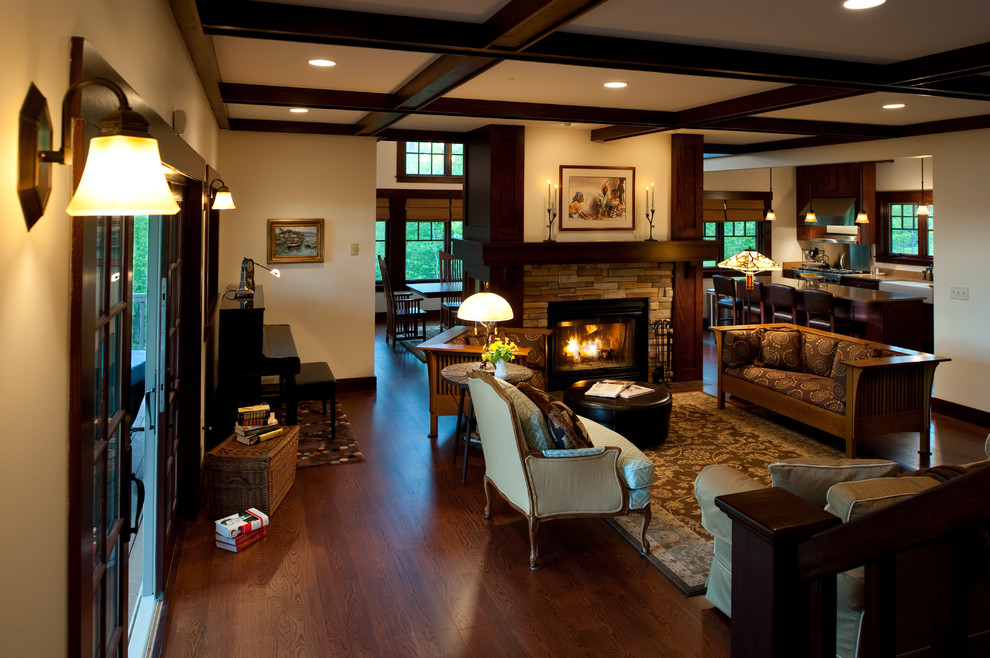 This is an example of a traditional formal open concept living room in Minneapolis with beige walls, dark hardwood floors, a standard fireplace and a stone fireplace surround.