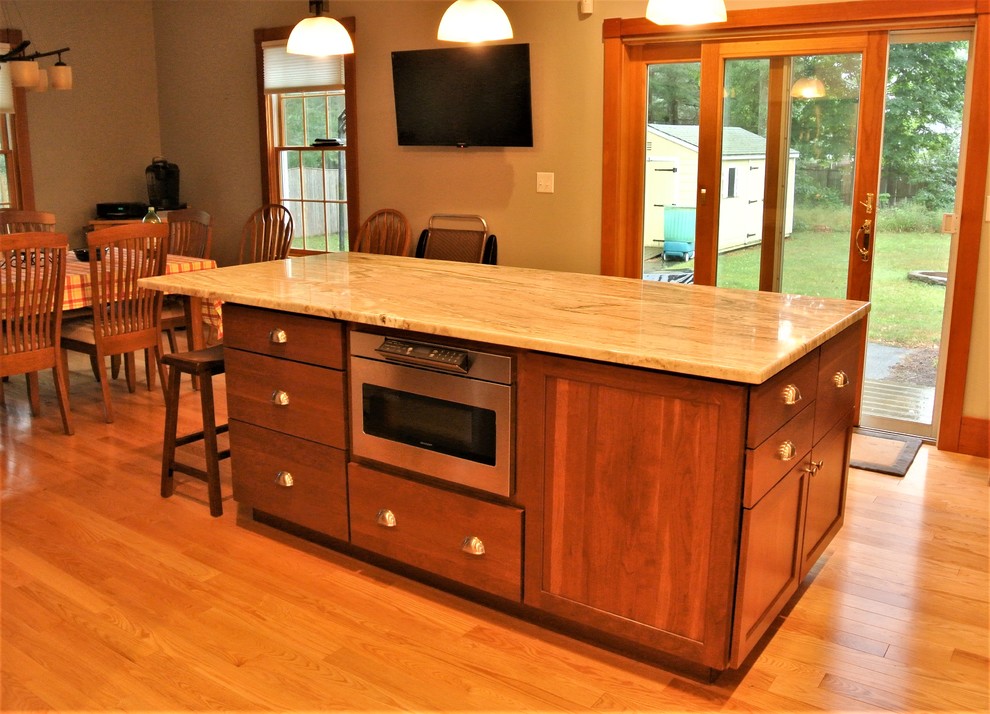 Inspiration for a transitional light wood floor kitchen remodel in Boston with an undermount sink, shaker cabinets, white cabinets, quartzite countertops, white backsplash, subway tile backsplash, stainless steel appliances and an island