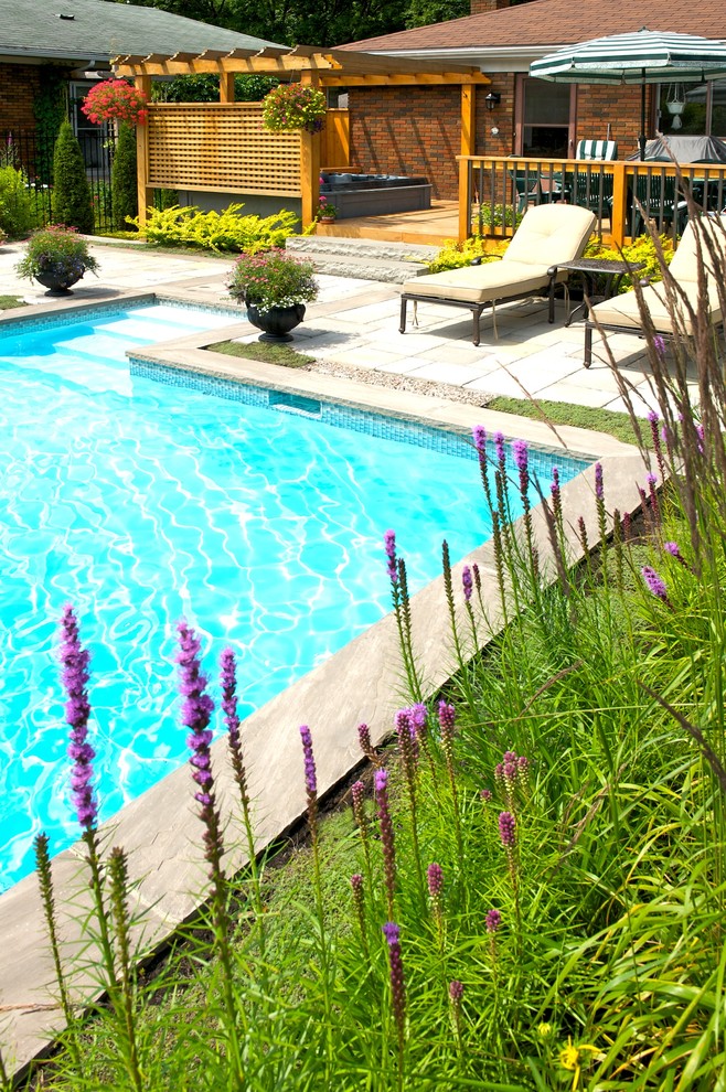 Mid-sized traditional backyard garden in Montreal with a water feature and concrete pavers.