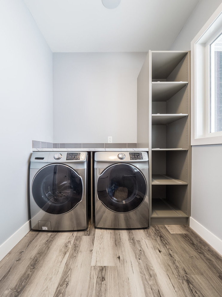 Inspiration for a large single-wall vinyl floor and multicolored floor dedicated laundry room remodel in Edmonton with quartz countertops, gray walls and a side-by-side washer/dryer