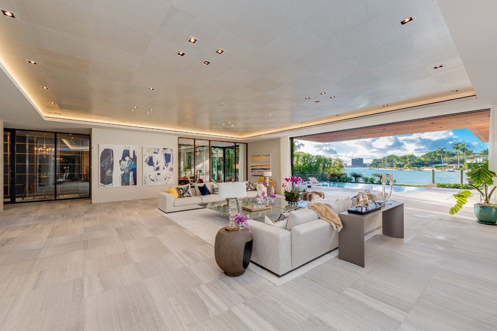 Contemporary open concept living room in Miami with beige walls and grey floor.
