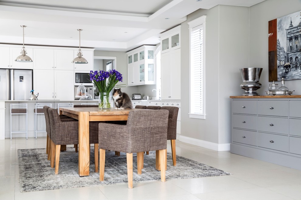 Photo of a large transitional kitchen/dining combo in Other with beige walls and porcelain floors.