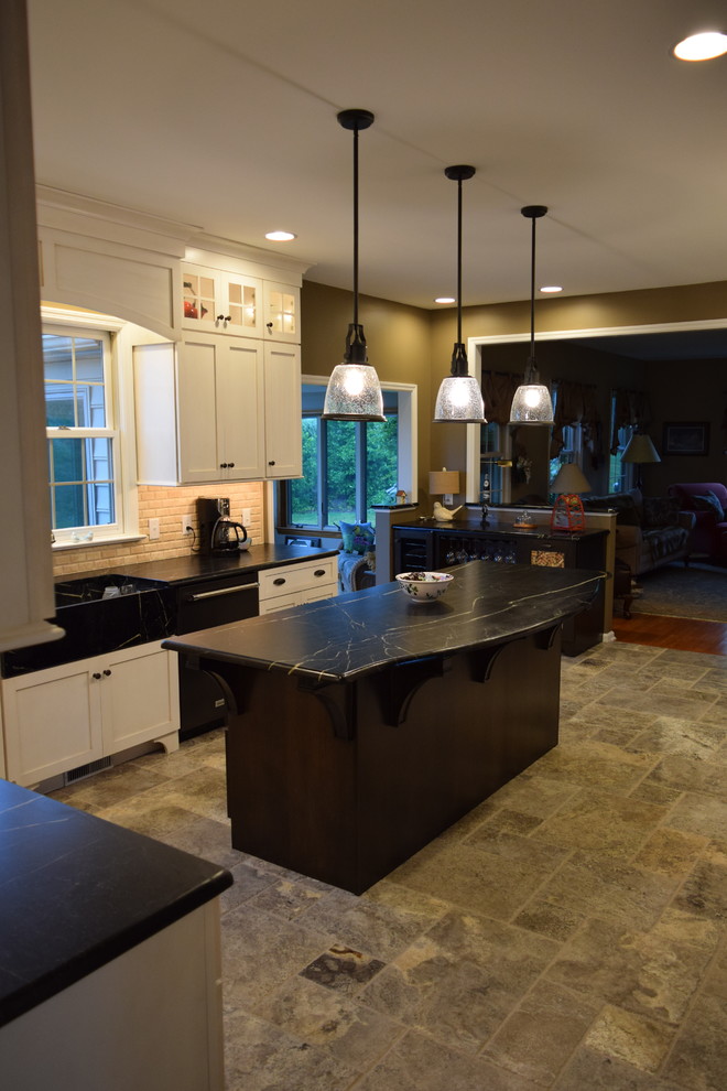 Transitional l-shaped ceramic tile kitchen photo with an undermount sink, shaker cabinets, white cabinets, quartz countertops, beige backsplash, subway tile backsplash, black appliances and an island