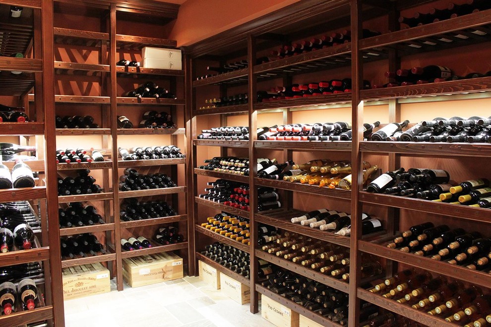 This is an example of a large traditional wine cellar in Philadelphia with limestone floors, storage racks and beige floor.