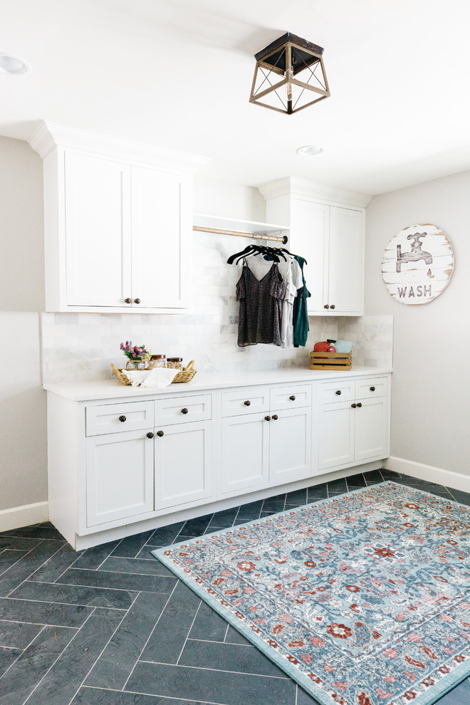 Design ideas for an expansive country galley dedicated laundry room in Phoenix with recessed-panel cabinets, white cabinets, quartz benchtops, grey walls, slate floors, a side-by-side washer and dryer and black floor.