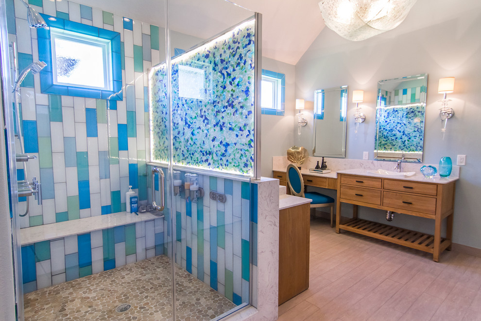 Design ideas for a large beach style master bathroom in Houston with a vessel sink, flat-panel cabinets, light wood cabinets, limestone benchtops, a corner shower, a two-piece toilet, beige tile, glass tile, green walls and light hardwood floors.