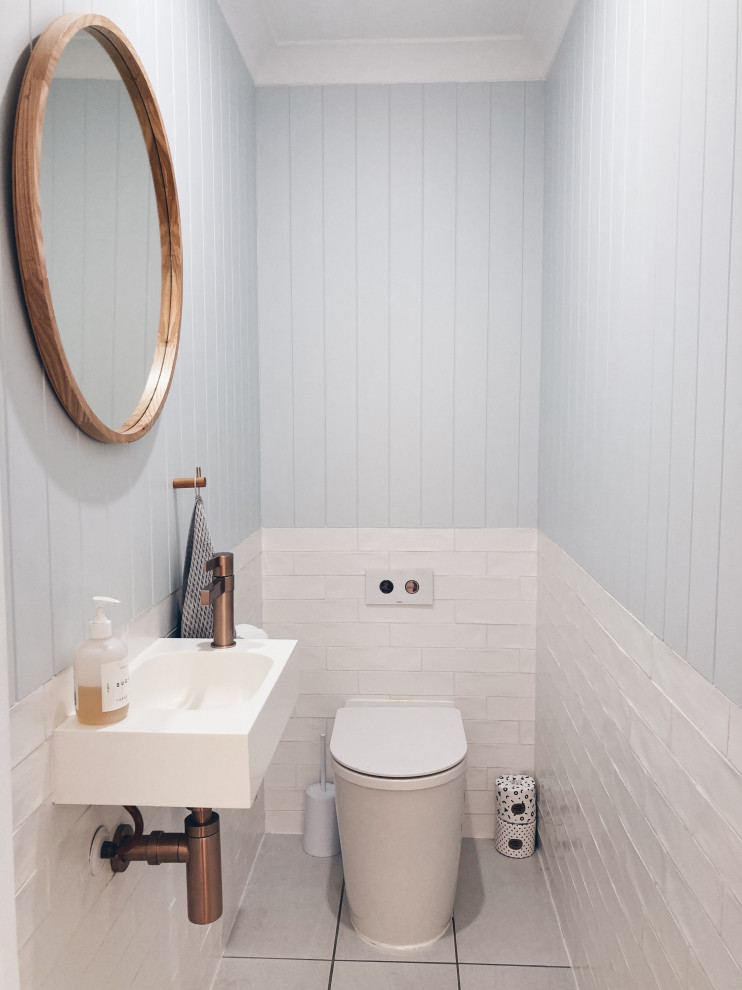 Idées déco pour un petit WC et toilettes contemporain avec WC à poser, un mur bleu, un sol en carrelage de céramique, un plan vasque, un sol gris, meuble-lavabo suspendu et du lambris de bois.
