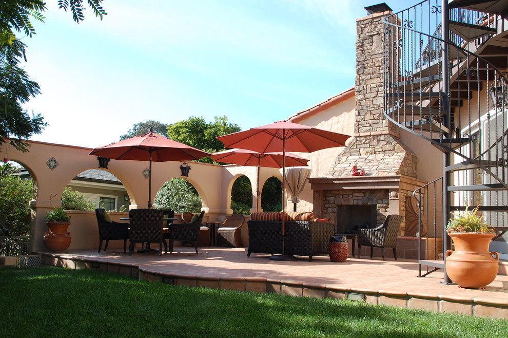 Inspiration for a large mediterranean backyard patio in San Diego with a fire feature, brick pavers and no cover.