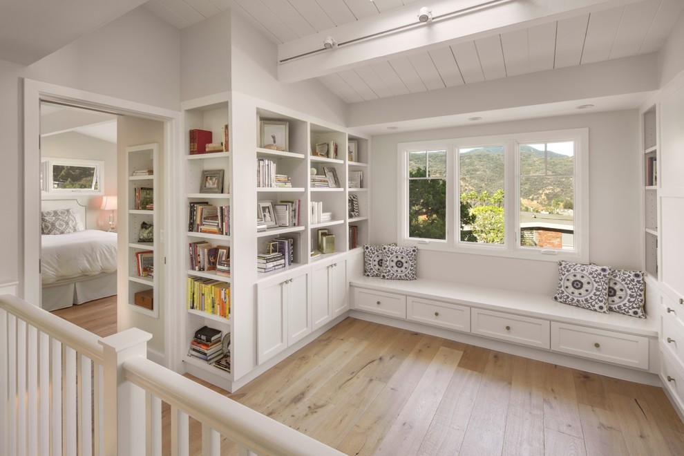 Photo of a mid-sized transitional loft-style family room in Los Angeles with a library, light hardwood floors and no tv.