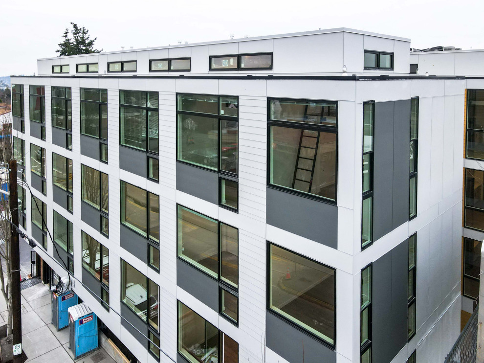 Großes, Vierstöckiges Modernes Wohnung mit Faserzement-Fassade, weißer Fassadenfarbe, Flachdach, Blechdach, grauem Dach und Wandpaneelen in Seattle