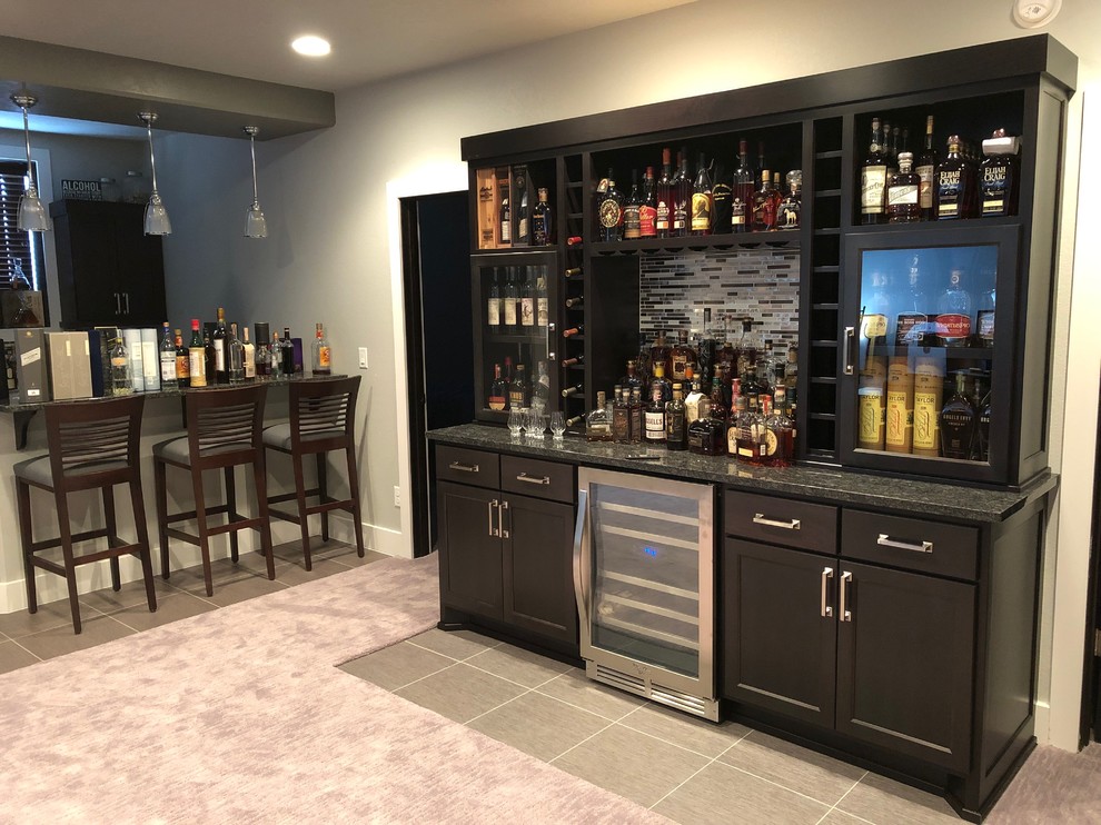 Design ideas for a mid-sized traditional single-wall home bar in Other with no sink, dark wood cabinets, granite benchtops, multi-coloured splashback, glass sheet splashback, vinyl floors, multi-coloured floor and multi-coloured benchtop.