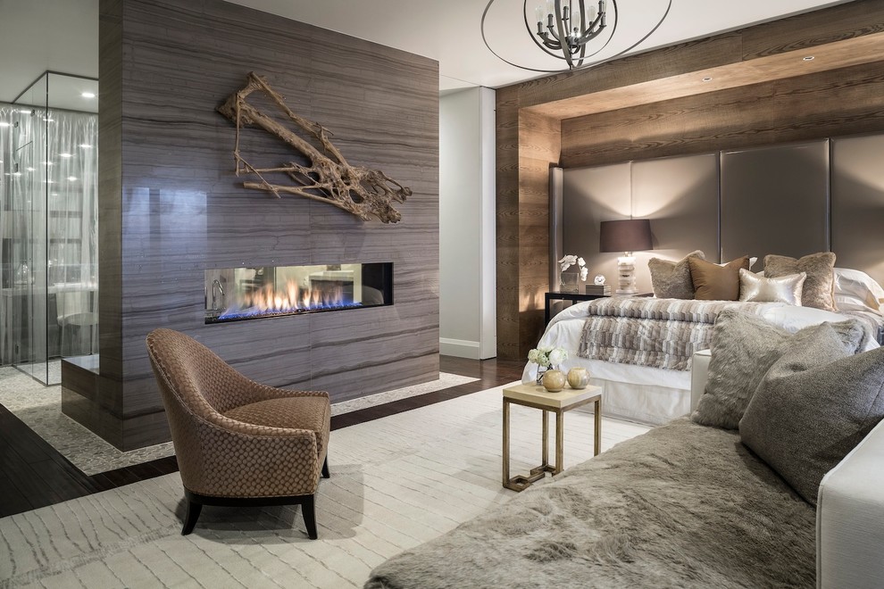 Example of a trendy master dark wood floor bedroom design in Other with a two-sided fireplace and a tile fireplace