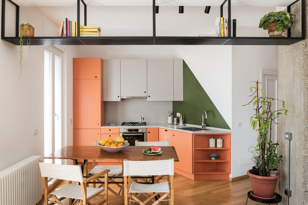 Design ideas for a medium sized contemporary l-shaped kitchen/diner in Rome with a single-bowl sink, flat-panel cabinets, orange cabinets, wood worktops, green splashback, stainless steel appliances, light hardwood flooring, no island, brown floors and grey worktops.