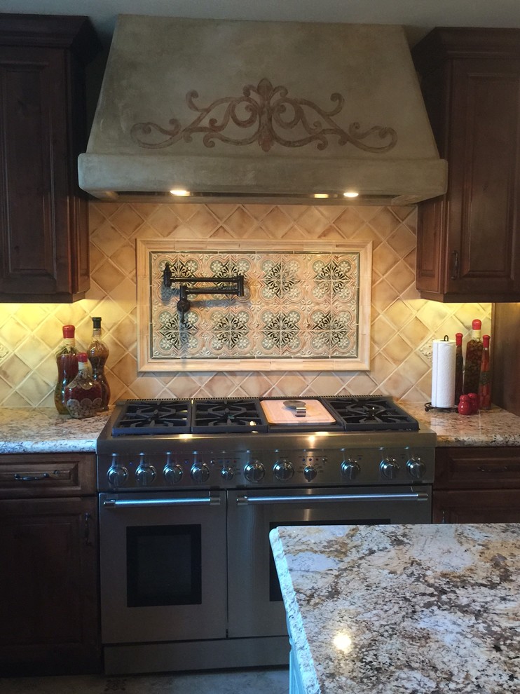 Inspiration for a mediterranean eat-in kitchen in Orange County with raised-panel cabinets, dark wood cabinets, marble benchtops, multi-coloured splashback, stone slab splashback and with island.