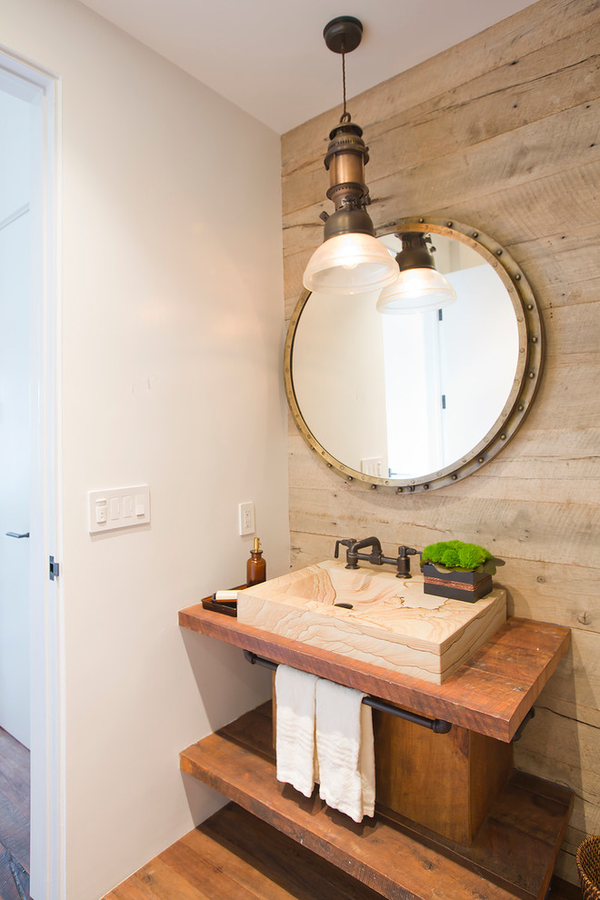 Photo of a small industrial powder room in Santa Barbara with a vessel sink, open cabinets, medium wood cabinets, medium hardwood floors and wood benchtops.