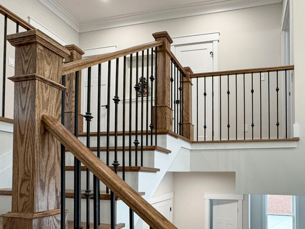 This is an example of a medium sized classic wood curved mixed railing staircase in DC Metro with wood risers.
