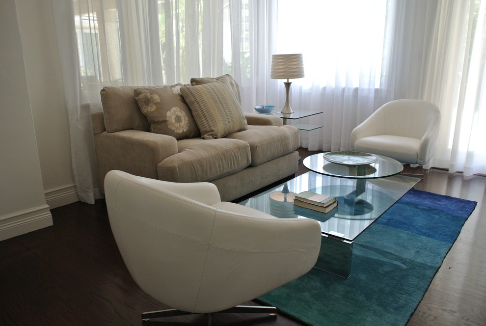 This is an example of a small contemporary enclosed family room in Miami with white walls and dark hardwood floors.
