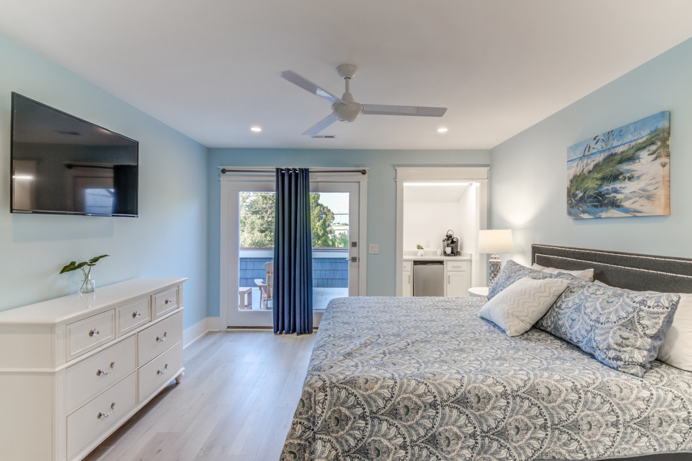 This is an example of a mid-sized beach style guest bedroom in Wilmington with blue walls, vinyl floors and grey floor.