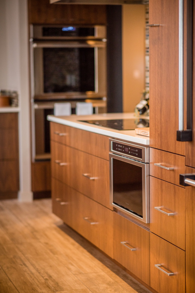 Example of a mid-sized mountain style l-shaped light wood floor and gray floor open concept kitchen design in Denver with an undermount sink, flat-panel cabinets, medium tone wood cabinets, quartz countertops, multicolored backsplash, mosaic tile backsplash, stainless steel appliances, an island and white countertops