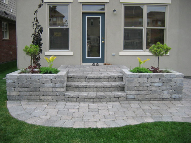 Photo of a transitional backyard brick landscaping in Toronto.