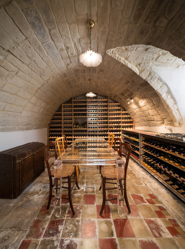 Inspiration for a mediterranean wine cellar in Other with storage racks and multi-coloured floor.