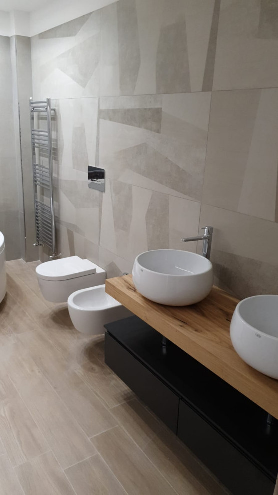 This is an example of a small modern powder room in Other with grey cabinets, a wall-mount toilet, multi-coloured tile, porcelain tile, multi-coloured walls, porcelain floors, a vessel sink, wood benchtops, brown floor and brown benchtops.