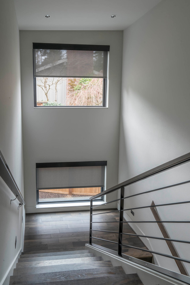 Photo of an expansive modern wood u-shaped staircase in Seattle with metal railing.