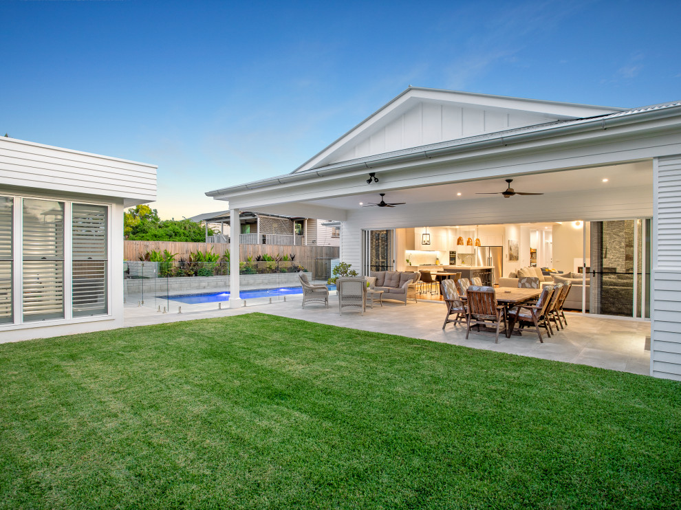Design ideas for a large beach style backyard verandah in Brisbane with an outdoor kitchen, tile and a roof extension.