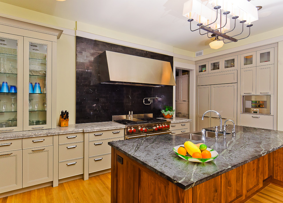 Large transitional u-shaped light wood floor eat-in kitchen photo in Calgary with a farmhouse sink, black backsplash, subway tile backsplash, paneled appliances, an island, beige cabinets and granite countertops