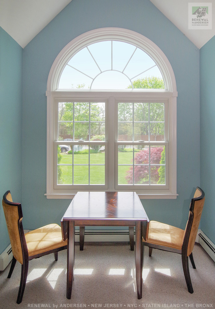 На фото: большой кабинет с синими стенами, ковровым покрытием, отдельно стоящим рабочим столом, бежевым полом и сводчатым потолком с