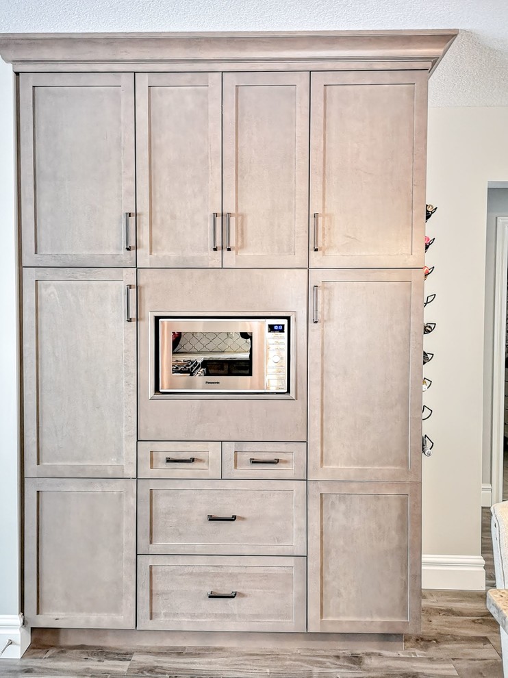 Inspiration for a mid-sized transitional l-shaped medium tone wood floor and brown floor open concept kitchen remodel in Toronto with an undermount sink, shaker cabinets, light wood cabinets, granite countertops, white backsplash, porcelain backsplash, stainless steel appliances, an island and beige countertops