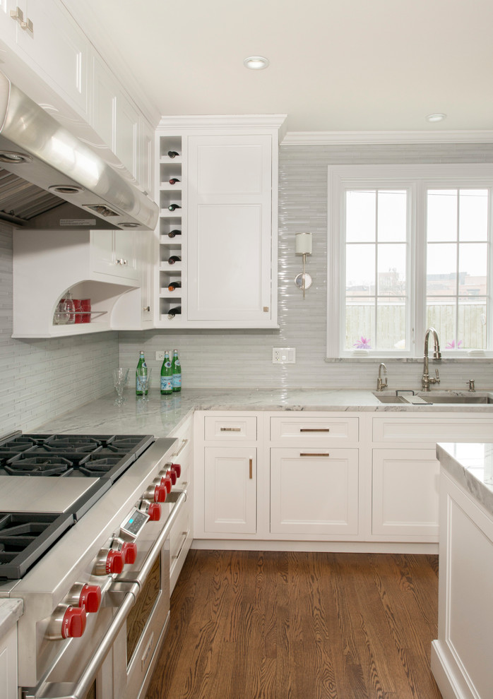 Eat-in kitchen - mid-sized transitional l-shaped dark wood floor eat-in kitchen idea in Chicago with an undermount sink, recessed-panel cabinets, white cabinets, quartzite countertops, white backsplash, glass tile backsplash, stainless steel appliances and an island