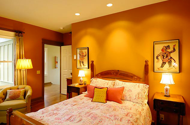 Inspiration for a mid-sized traditional master bedroom in Seattle with orange walls and medium hardwood floors.