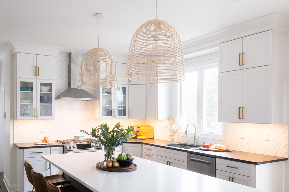 Inspiration for a large transitional l-shaped brown floor kitchen pantry remodel in Baltimore with a drop-in sink, shaker cabinets, white cabinets, quartz countertops, white backsplash, ceramic backsplash, stainless steel appliances, an island and white countertops