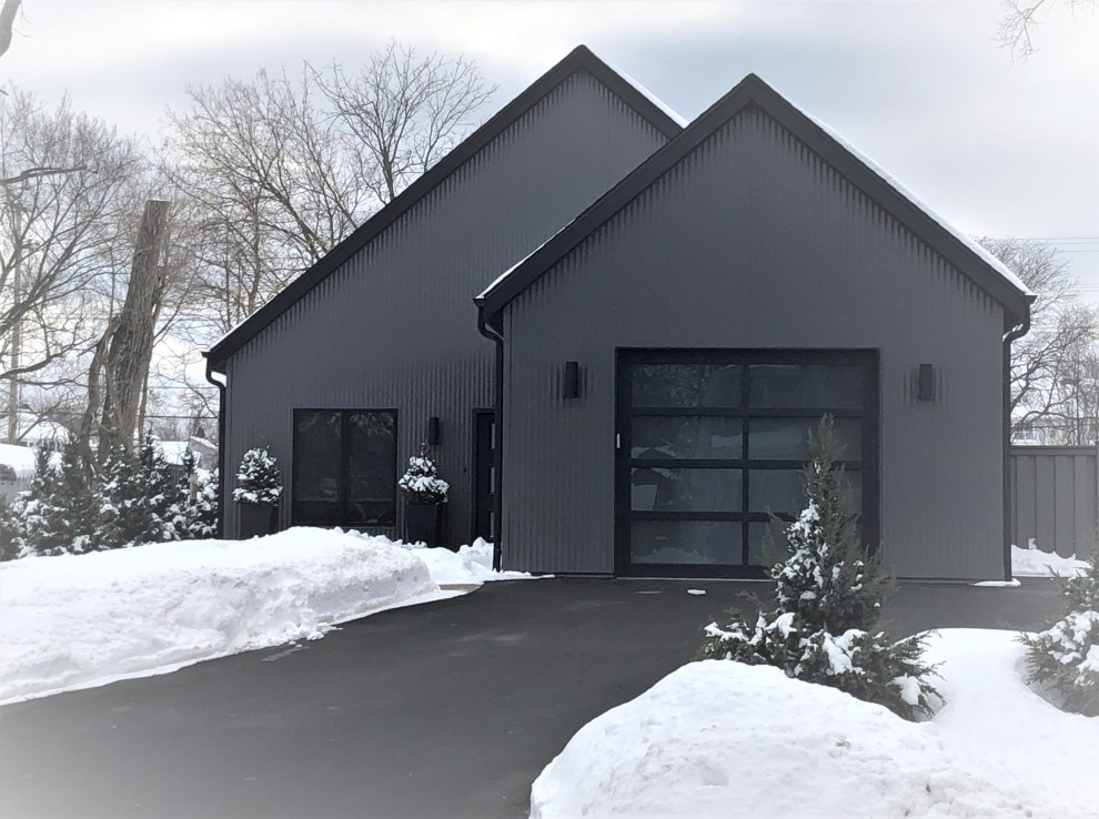 Idée de décoration pour une façade de maison métallique et grise design de taille moyenne et de plain-pied avec un toit à deux pans, un toit en shingle et un toit noir.