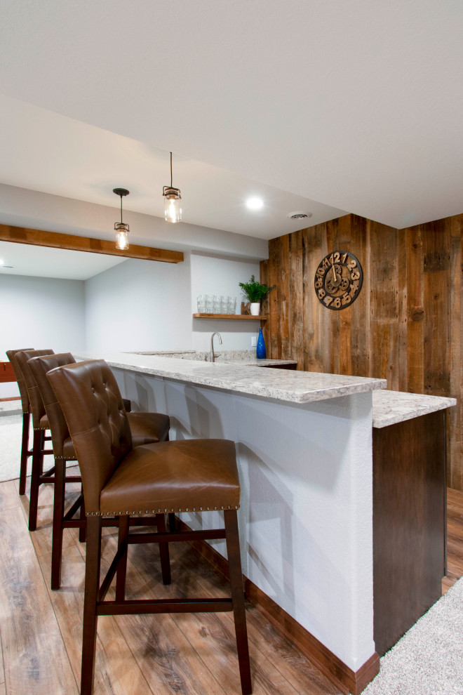 Inspiration for an expansive transitional fully buried basement in Milwaukee with a home bar, grey walls, vinyl floors, beige floor, exposed beam and wood walls.