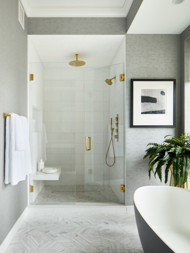 Стильный дизайн: большая главная ванная комната в стиле модернизм с серыми фасадами, отдельно стоящей ванной, белой плиткой, мраморной плиткой, серыми стенами, полом из мозаичной плитки, столешницей из искусственного кварца, белым полом, белой столешницей, сиденьем для душа, тумбой под две раковины и обоями на стенах - последний тренд
