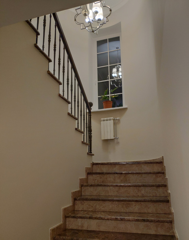 Foto de escalera en U clásica con escalones de mármol, contrahuellas de mármol y barandilla de metal